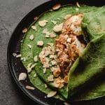 Green Crepes with Almond Flakes on Black Ceramic  Plate